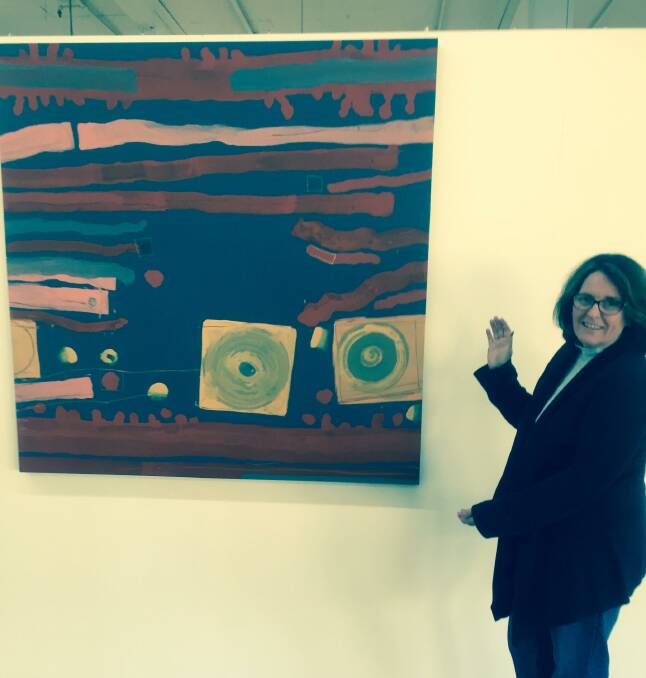 Wellington Arts president Danielle Anderson points to a painting by Australian artist Tim Winters.