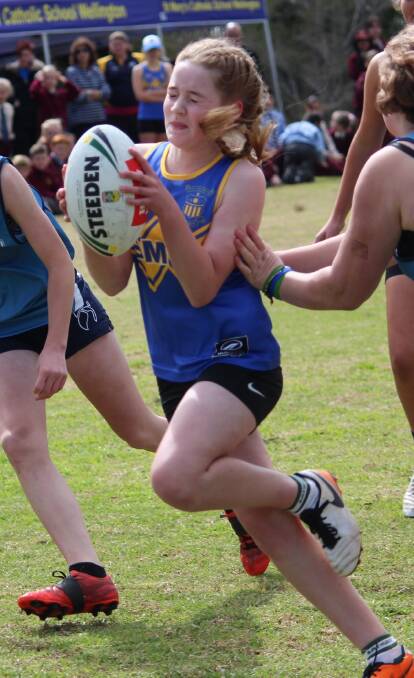 Wellington High defends as St Mary's player Sophie Whiteman runs the ball in the Don Green Local Derby Cup. 