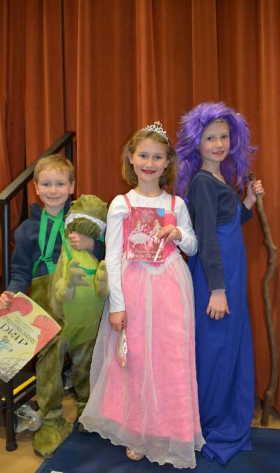 Novel characters: Siblings Markus, Katie and Charlotte Ivey dress up with stories in hand during the annual Children's Book Week. Photo: FAYE WHEELER