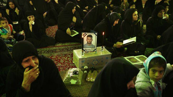 IRAN TO IRAQ GALLERY
Women surround a framed photo of asylum seeker Reza Barati, during the memorial service held at the Al-Mahdi mosque in the Nabard neighbourhood in South East Tehran, Iran. 27th Feburary, 2014. Photo: Kate Geraghty Photo: Kate Geraghty