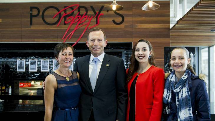 The opening of Poppy's cafe at the Australian War Memorial. Trooper David Pearce's daughters Hannah and Stephanie (red), widow Nicole Pearce with Prime Minister Tony Abbott. Photo: Jay Cronan