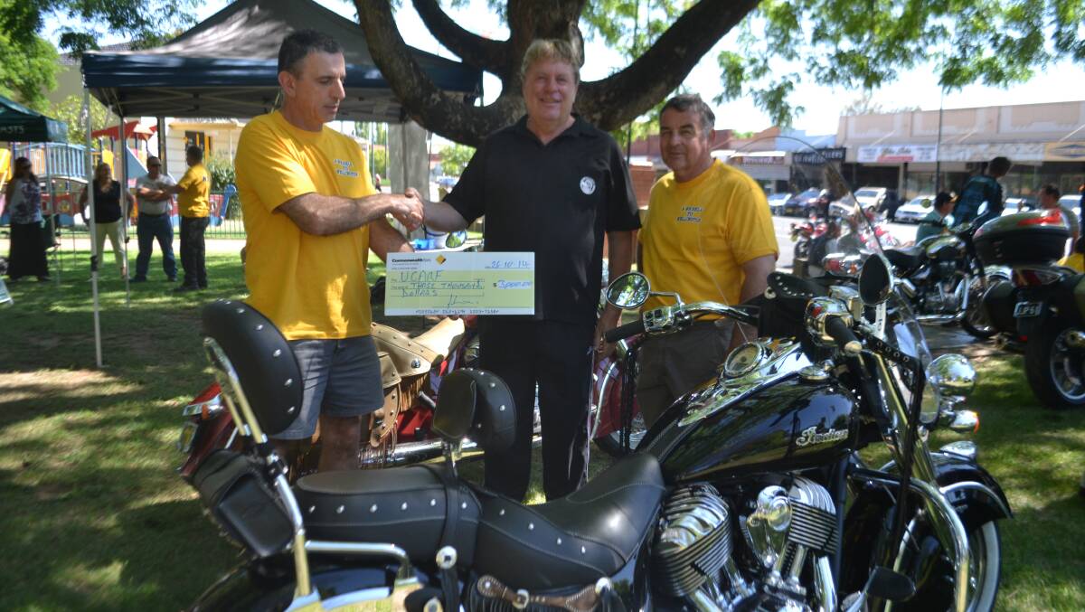 John Jannis and Phil Mellihuish present Kim Kennerson with a cheque for Arthritis Research
