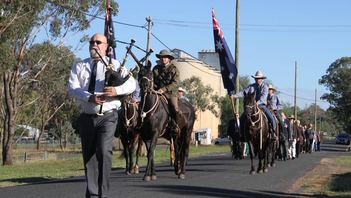 A bagpiper and riders, horses led the Geurie Anzac day service