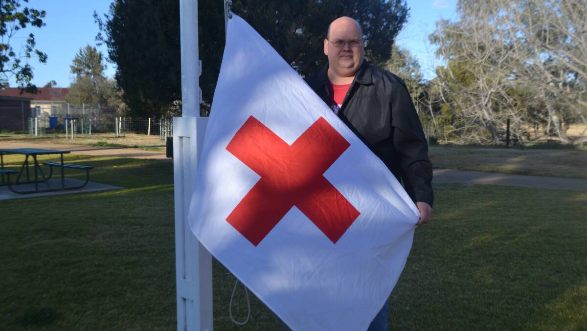 Community man Marcus Hanney with the Red Cross flag