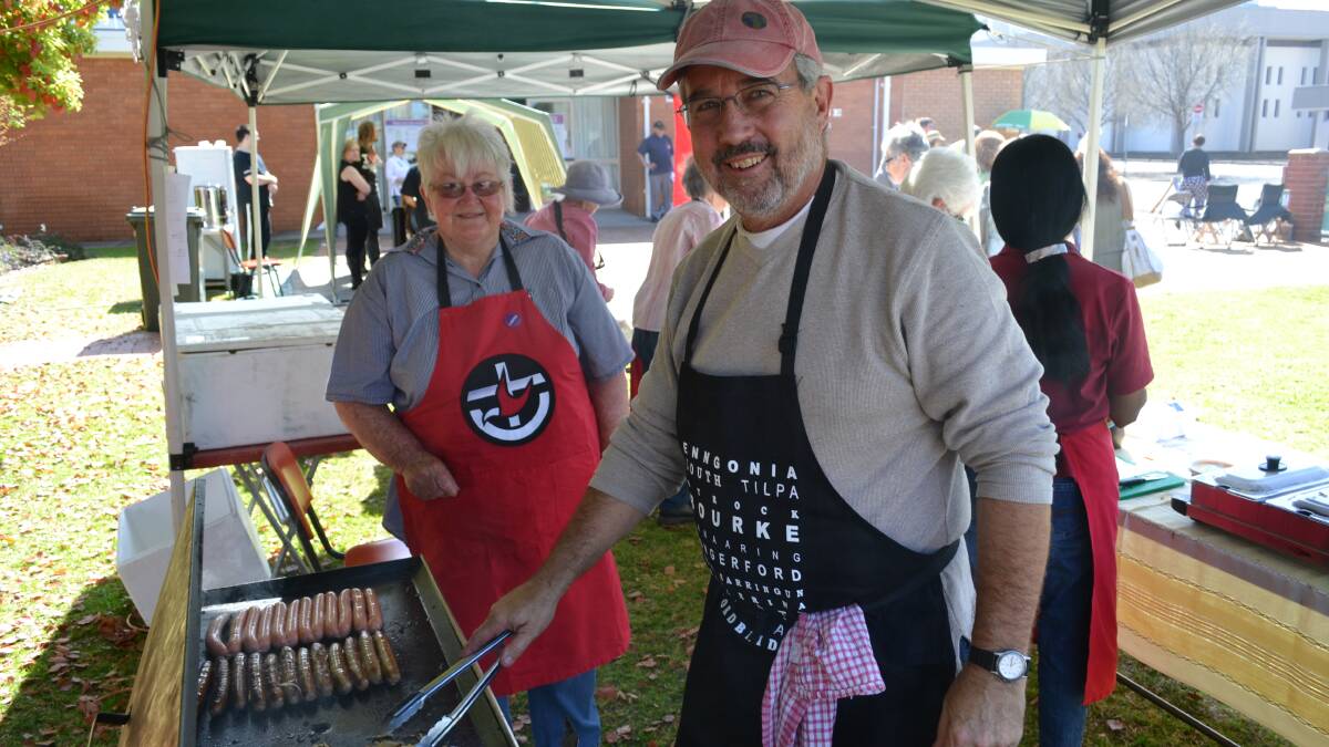 Diana Evans keeps a close eye on the sausage turning skills of Dan Eaton at the Dubbo Uniting Church hall on Saturday morning. They will put in a shift from 7.30am to 1pm. The snags were from Woolies, the eggs from the parishioners as were the cakes and produce that were also on sale.