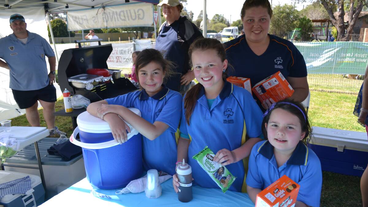 Helping with the barbecue at the Girl Guides hall in West Dubbo were guides Indiana Cleary, Kyla and Breanna Turner while Natasha Wheeler [rear] helped with Girl Guides biscuits. Manning the barbecue [back] were Guy Turner and Andy Swinn.