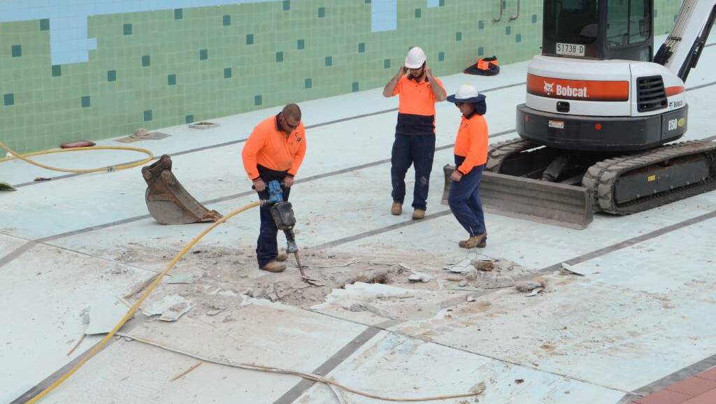 Workers drill into the base of the 50-metre swimming pool as part of investigative work to determine preferred construction of the replacement pool.