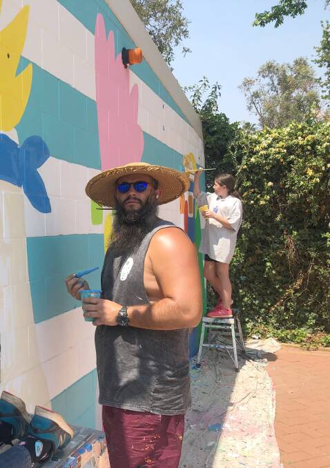 WORKING TOGETHER: Mulga and Hannah Austin spruce up the wall. Photo: SUPPLIED
