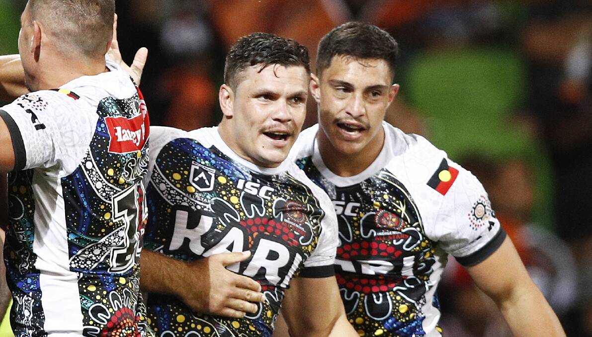 ALL SMILES: James Roberts and Kotoni Staggs celebrate a try from the Indigenous side. Photo: AAP