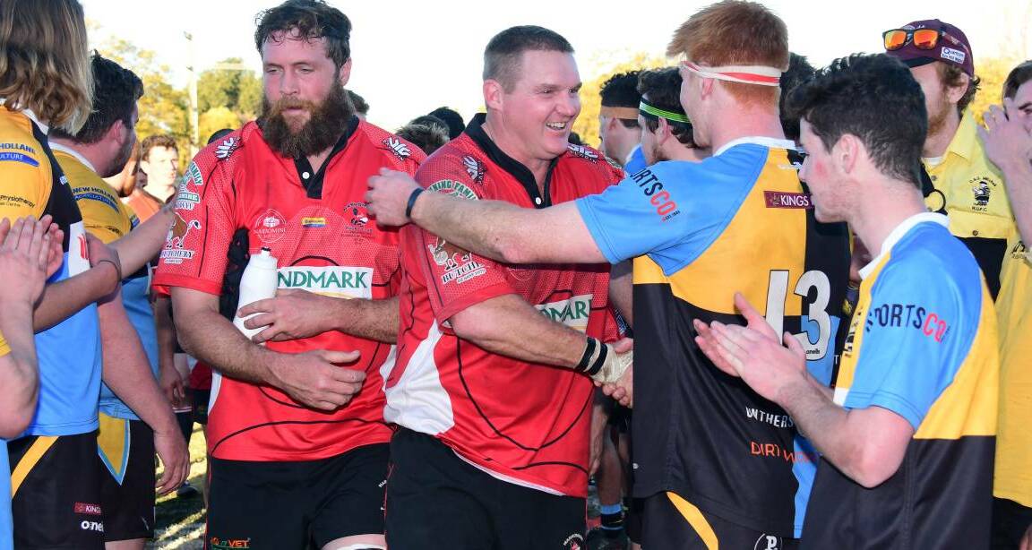 FOR THE LOVE OF RUGBY: Craig Campbell, with a big grin on his face despite just losing a grand final, shakes CSU Bathurst's Regan Hughes' hand. Photo: AMY McINTYRE