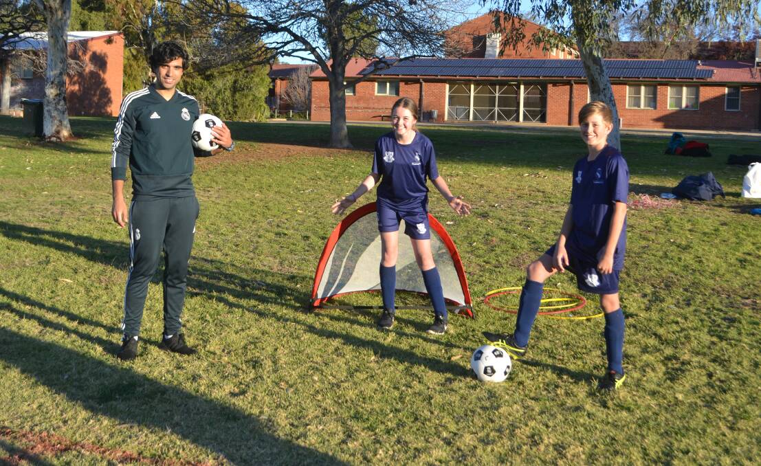 Goal: Real Madrid Foundation trainer Antonio Vilar running drills with Wellington High School students Emerson Humphries and Lochlan George. Photo: Taylor Jurd.