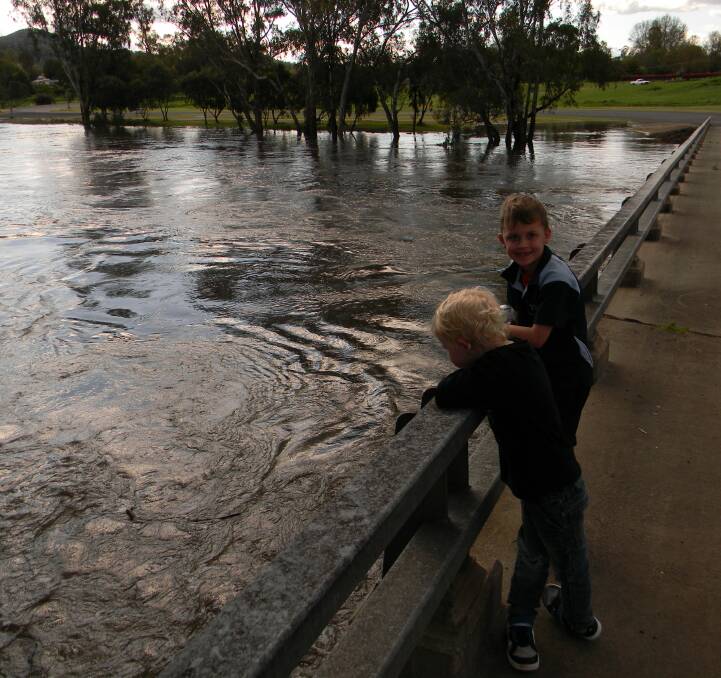 Vantage point: Toby Day, 4 and Sam Day, 6, came to the Duke of Wellington Bridge with their 'Ma' to see the swollen Macquarie River on Friday. Photo: FAYE WHEELER