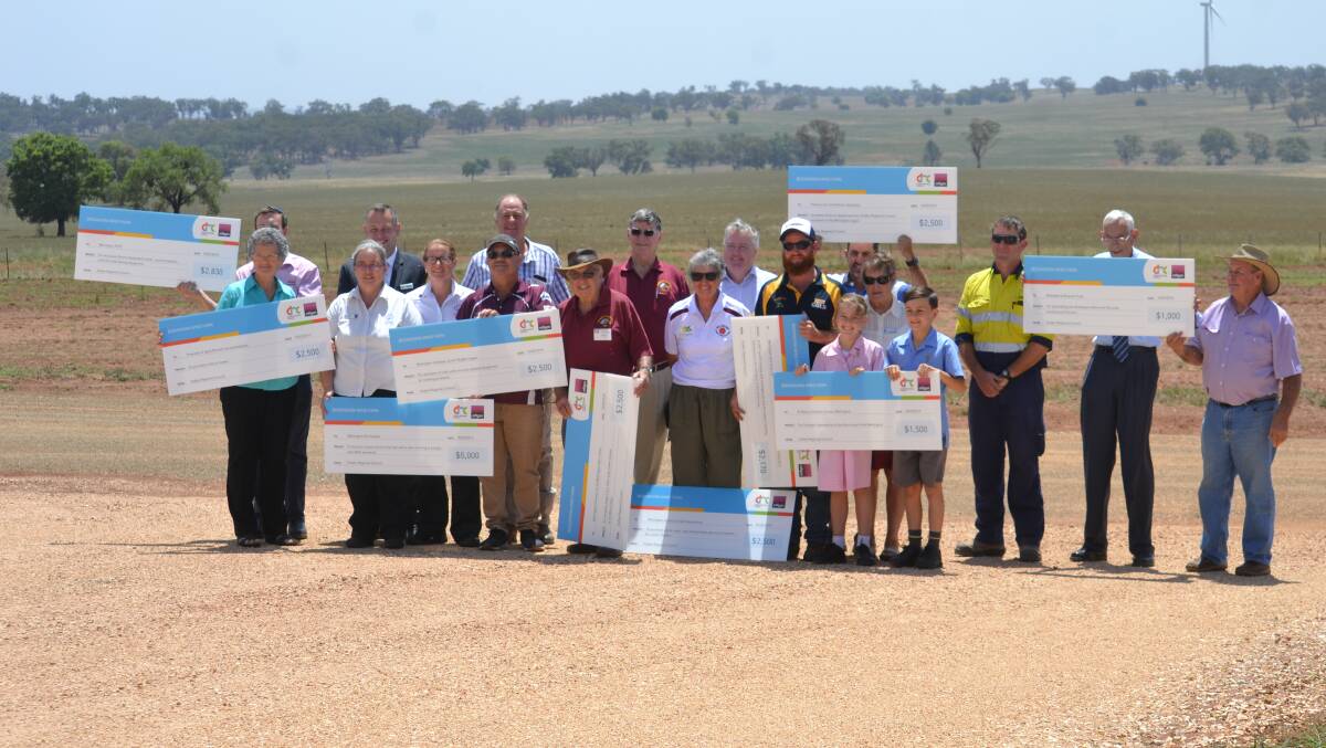 Recipients of the previous round of funding hold their cheques up at a meeting at Bodangora Wind Farm. Photo: Daniel Shirkie.