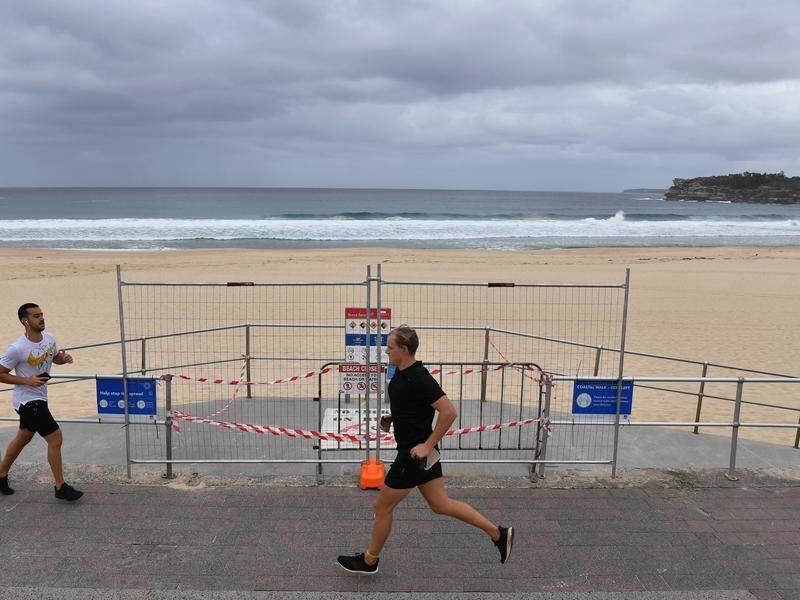 People will be able to swim or surf off Bondi Beach from Tuesday, but the sand remains closed .