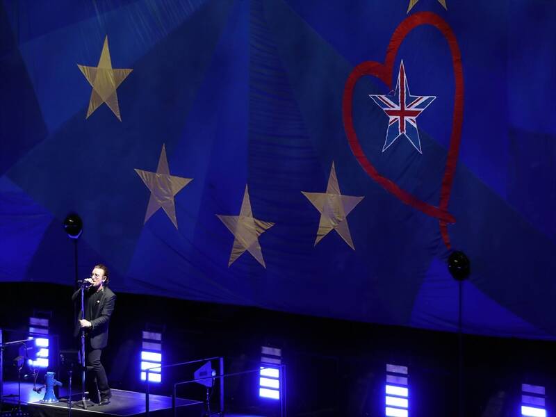 U2's Bono performs in front of a giant EU flag in London with one star showing the Union Jack.