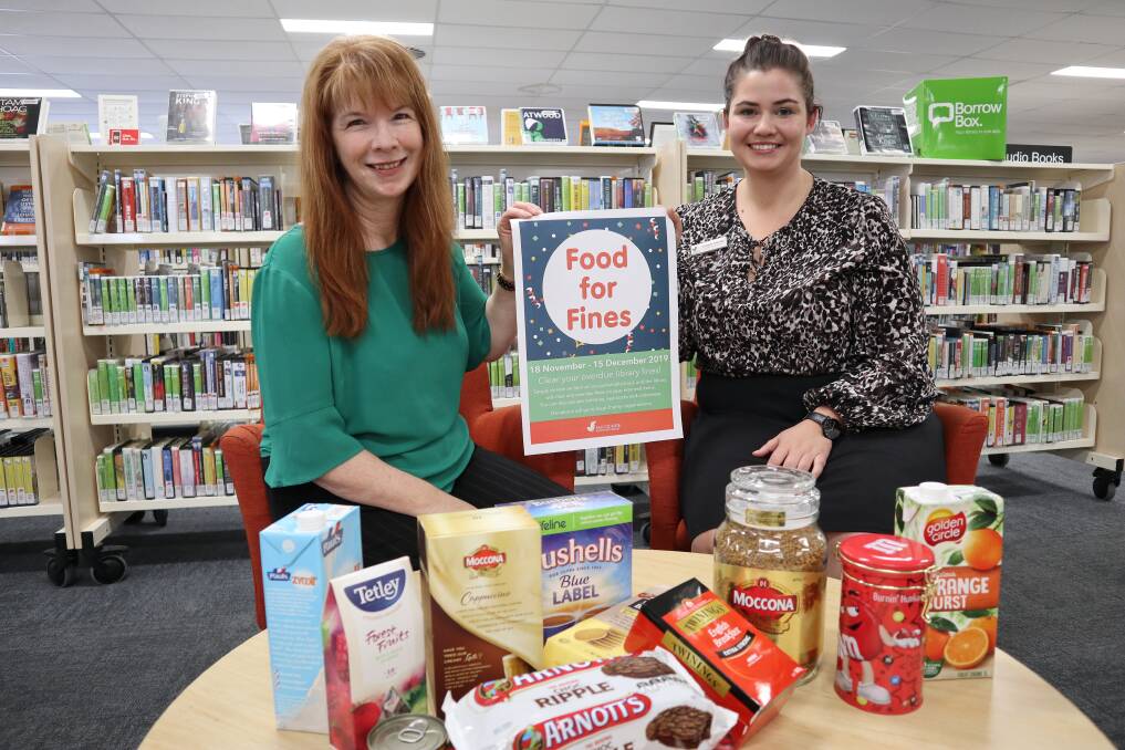 FEES WAIVED: Macquarie Regional Library manager Kathryn McAlister and Wellington branch librarian Victoria Murray are encouraging people to donate food. Photo: CONTRIBUTED
