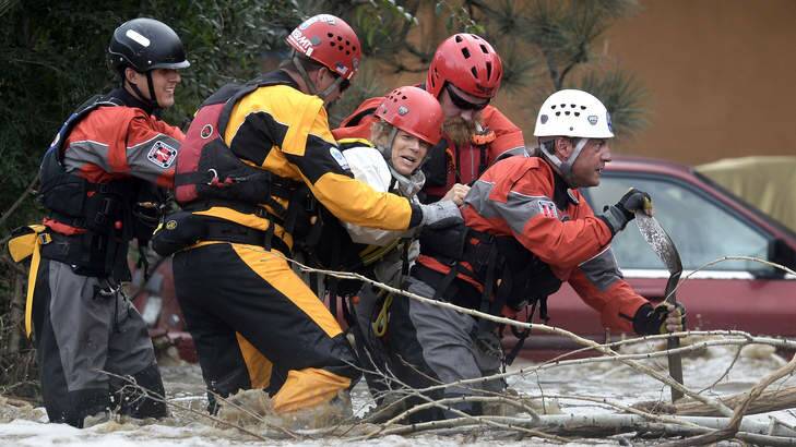 The Summit County Rescue team works to save Suzanne Sophocles, centre, from her severely flooded home  in Boulder, Colorado on  Friday. Photo: Jeremy Papasso